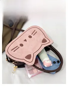 Pink cartoon cat handbag showing internal capacity for phone and cosmetics accessories