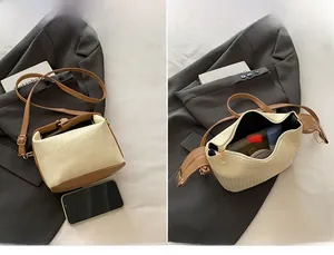 Detail view of cream textured handbag showing interior main pocket and zip closure