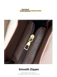 Close-up of golden metal zipper on pink and brown textured leather crossbody bag
