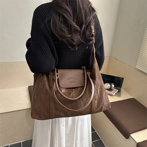 Brown large capacity travel tote bag with pleated texture and adjustable strap for women