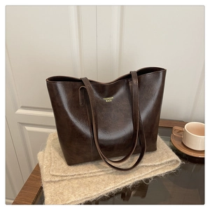 Détail du sac cabas marron foncé vintage avec texture brillante et texte doré élégant