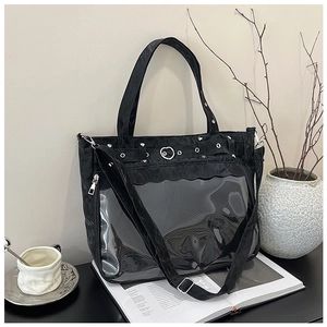 Détail du sac cabas noir avec poche transparente en PVC et boucle en forme de cœur