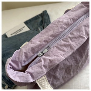 Vue détaillée de la fermeture éclair argentée et du tissu en nylon violet du sac cabas
