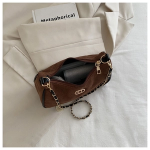 Detail view of brown suede underarm bag interior showing storage space for wallet and power bank