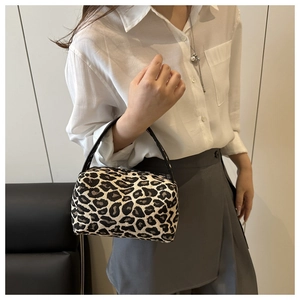 Close-up of the black and white leopard print fabric and leather handle on this mini handbag