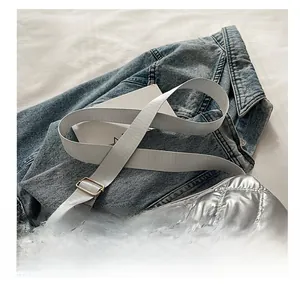 Detail of adjustable nylon strap and metallic quilting on the silver shoulder bag