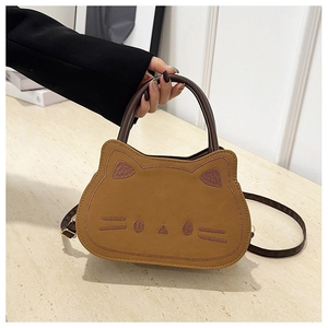 Detail of cute brown cat-shaped shoulder bag featuring embroidery whiskers and soft texture