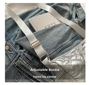 Detail showing the adjustable metal buckle on a silver quilted shoulder bag strap