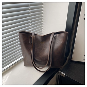 Détail du grand sac cabas marron avec lettrage doré et texture mate au style rétro