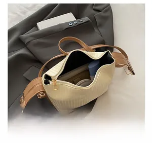 Detail showing the large interior capacity of this pleated shoulder bag with daily items