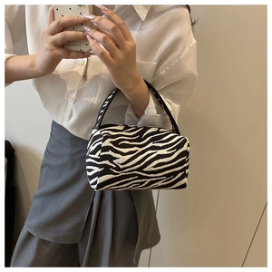 Detailed view of black and white zebra pattern fabric on a stylish mini pillow handbag