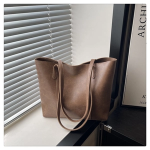 Gros plan d'un sac cabas marron vintage avec fines lanières et logo doré