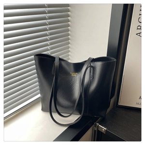 Gros plan d'un sac cabas noir avec texte doré Fashion Bags sous une lumière naturelle