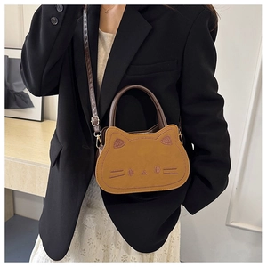 Brown cat-shaped crossbody bag shown on a model wearing a black blazer and lace dress
