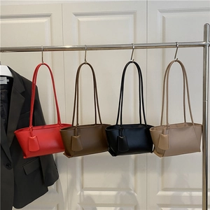 Sacs cabas rétro rouge, marron, noir et beige présentés sur un support minimaliste