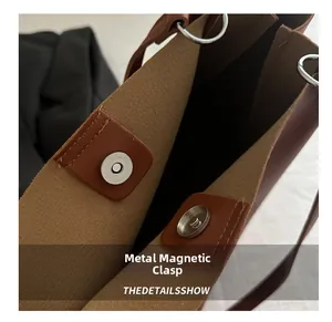 Dettaglio della chiusura magnetica e dell'anello d'argento su una borsa tote in pelle marrone