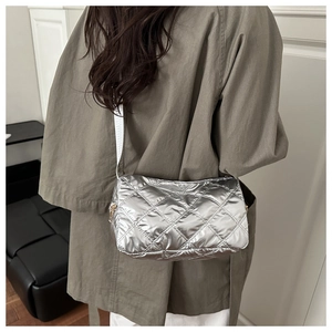 Detail of silver quilted hobo bag with metallic finish and diamond stitch pattern