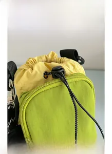 Détail du sac à bandoulière en nylon imperméable avec cordon et boucle ajustable
