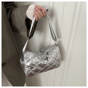 Detail of silver quilted puffer bag featuring metallic nylon and gold-tone zipper closure