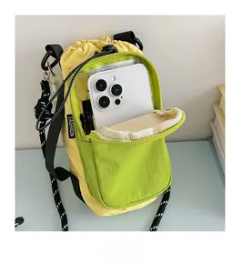 Détail du sac bandoulière en nylon avec cordon et poche avant pour rangement de téléphone