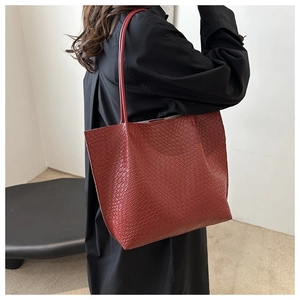 Macro detail of red woven texture and long shoulder straps on a large tote bag