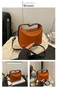 Detail of pleated orange-brown PU handbag with golden hardware and adjustable strap