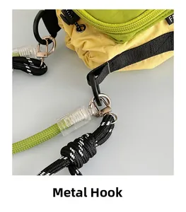 Détail du sac extérieur montrant les crochets métalliques et les sangles en nylon vert