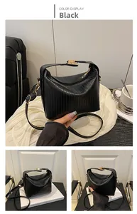 Detailed macro view of black pleated leather hobo bag with elegant golden hardware accents