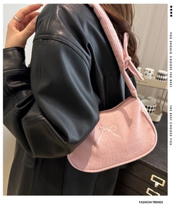 Détail du sac à bandoulière en velours côtelé rose avec broderie nœud blanc sur cuir