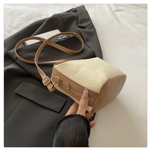 Detail of color-block square handbag with cream textured fabric and brown leather strap