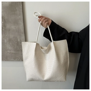 Detail of cream oversized tote bag showing premium crocodile embossed faux leather texture