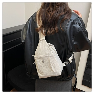 Close-up of beige nylon chest bag with gabardine texture and metal logo detail