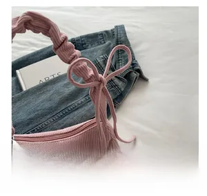 Détail d'un sac d'épaule en velours côtelé rose avec poignée plissée et texture douce