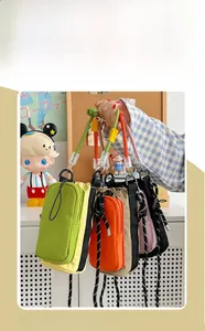 Détail de mini sacs à bandoulière en nylon avec cordon en vert, orange et rose vif