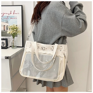Détail du sac cabas en toile blanche avec boucle cœur et poche transparente en PVC