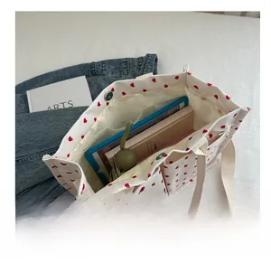 Internal view of a white corduroy tote bag showing spacious capacity and red heart pattern