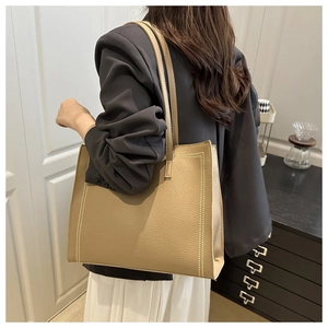 Side view of large khaki tote bag with white contrast stitching on pebble leather