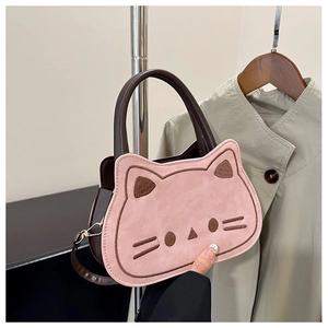 Detail of pink cat-shaped crossbody bag with brown embroidery and golden metal clasp