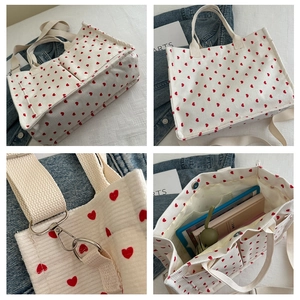 Detail view of corduroy tote bag with red heart patterns and removable shoulder strap