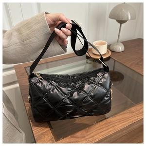 Close-up of black quilted nylon shoulder bag with shiny finish and gold zipper detail