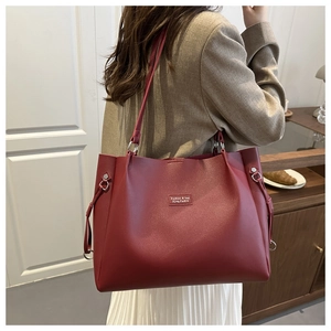 Dettaglio della borsa tote rossa capiente con fibbie argentate e texture in ecopelle