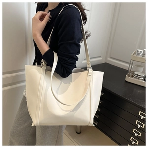 Minimalist white leather tote bag shown on model for elegant over-the-shoulder look