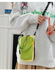 Gros plan d'un petit sac bandoulière en nylon vert et jaune avec bandoulière en corde tressée
