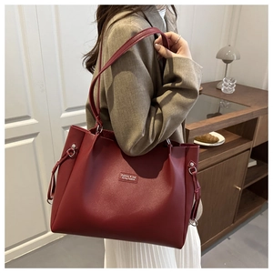 Dettaglio della borsa tote bordeaux con pelle a grana e coulisse laterali regolabili
