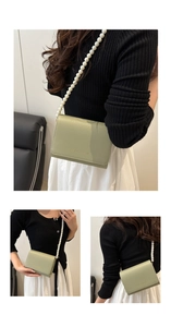 Détail du sac bandoulière vert clair avec bandoulière perles et logo doré