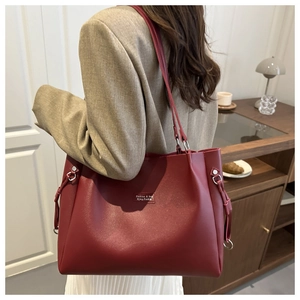 Dettaglio della borsa tote in pelle bordeaux opaca con elegante anello di metallo laterale
