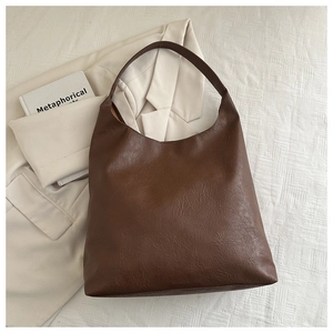 Detailed close-up of dark brown faux leather hobo bag with vintage lychee texture