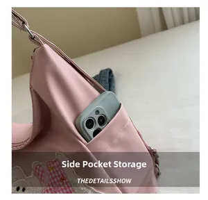 Detailed side view of pink backpack featuring side pocket and cute rabbit embroidery detail