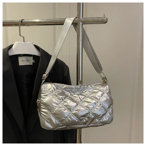 Detailed close-up of a silver quilted shoulder bag featuring premium metallic finish and strap