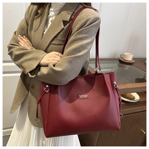 Dettaglio di una grande borsa tote in pelle bordeaux con elegante scritta in rilievo